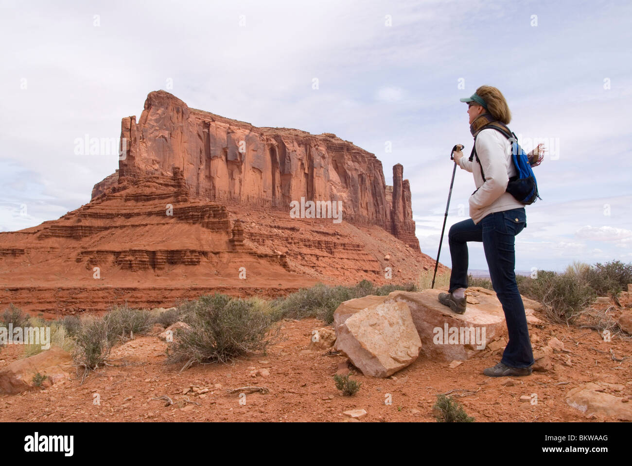 Hiker in foreground with the buttes and mesas of the Navajo Tribal Park in background Monument Valley Utah USA Kim Paumier MR Stock Photo