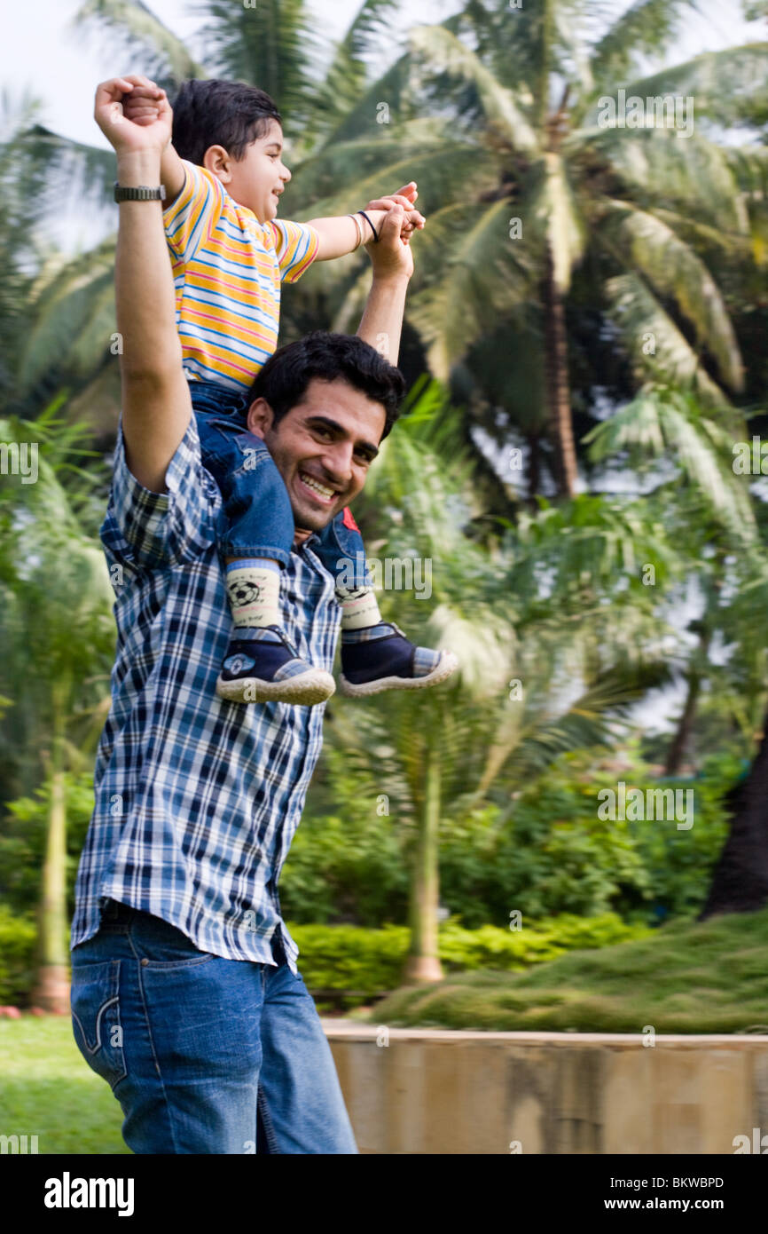 A father carries his son on his shoulders Stock Photo - Alamy