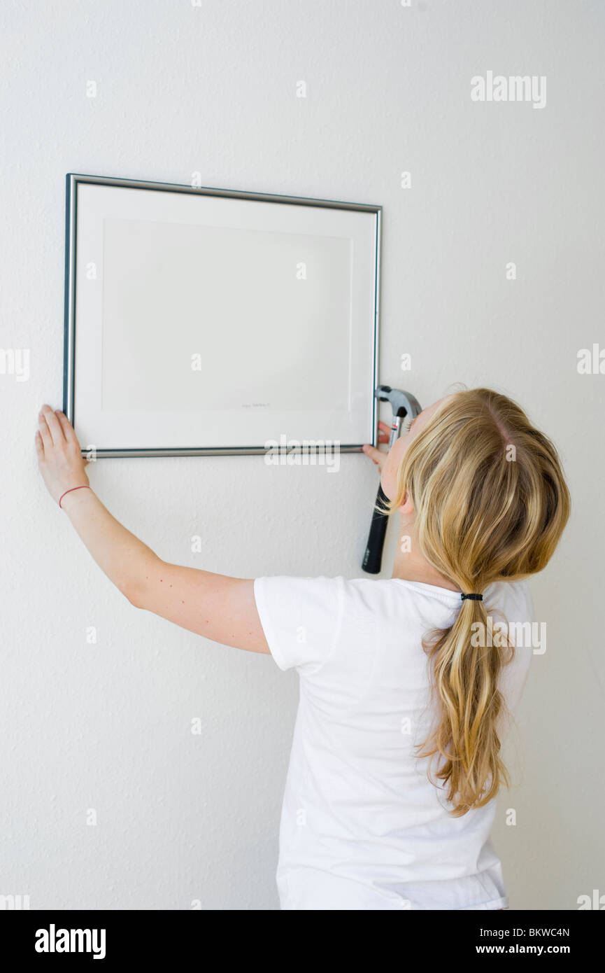 Woman putting up painting Stock Photo