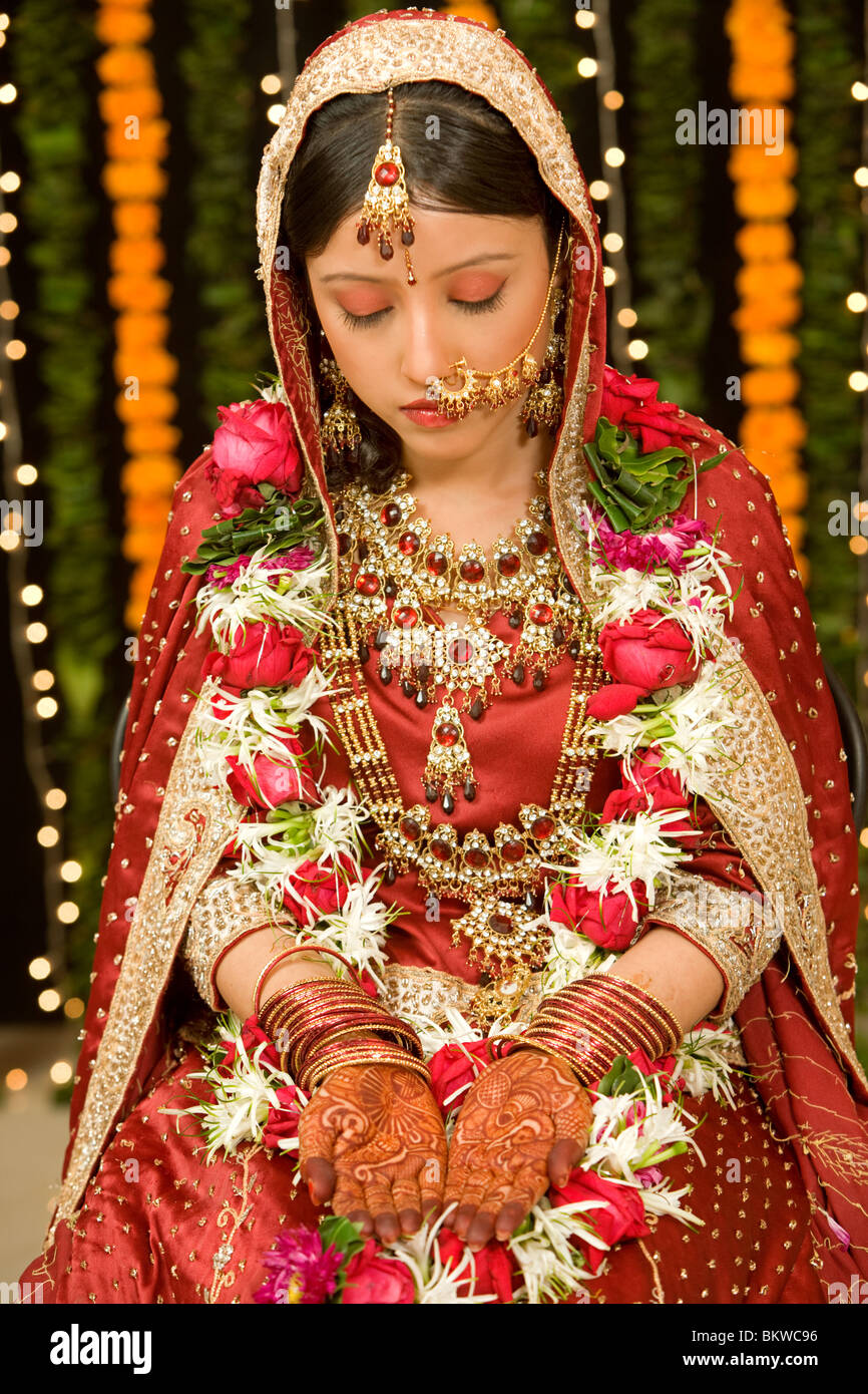 Indian bride looking at her hands with henna tattoo Stock Photo - Alamy