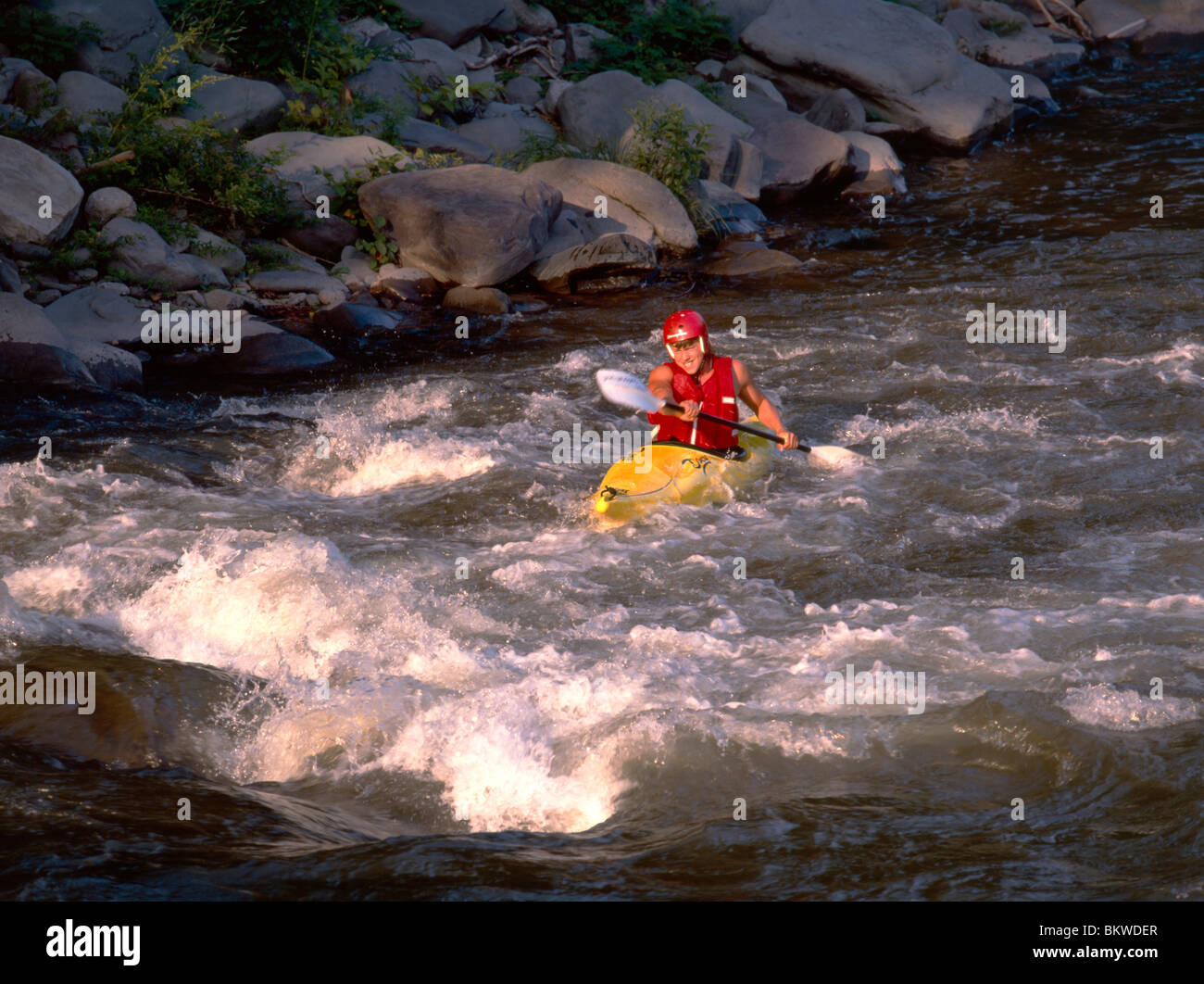 Young male kayaker paddling upstream in the Esopus Creek, Catskill