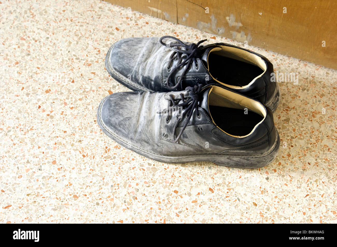 a pair of dirty black work shoes covered with cement or plaster dust Stock  Photo - Alamy