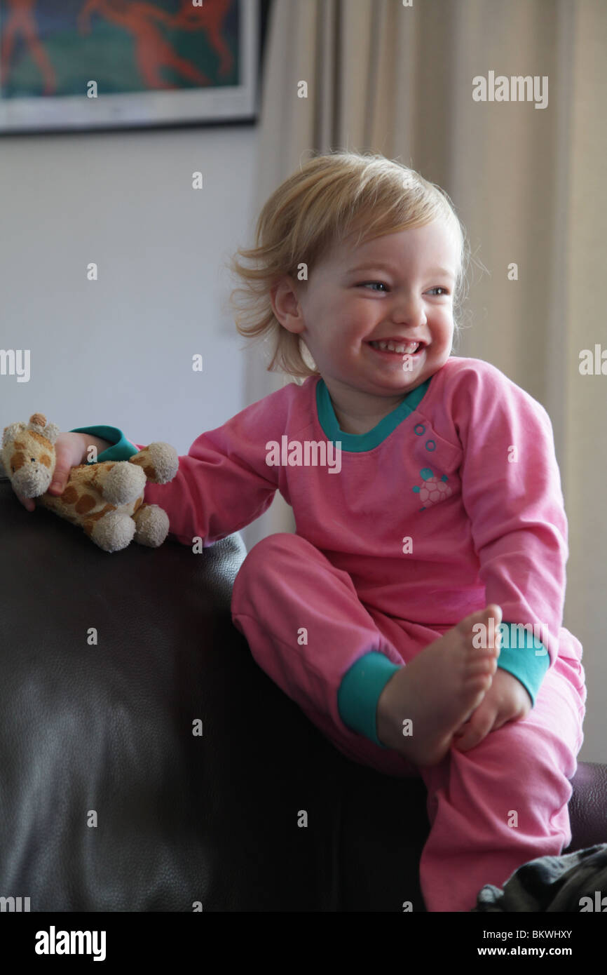 two year old child baby girl sit sitting sat sofa couch soft toy hold