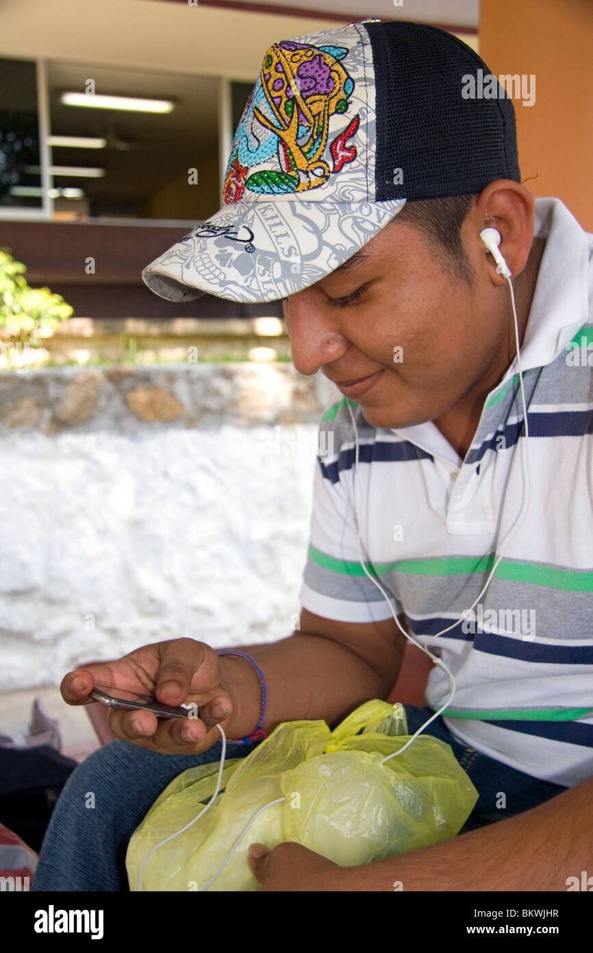 College student listening to an ipod on the campus of Universidad Autonoma de Guerro located in Acapulco, Guerrero, Mexico. Stock Photo