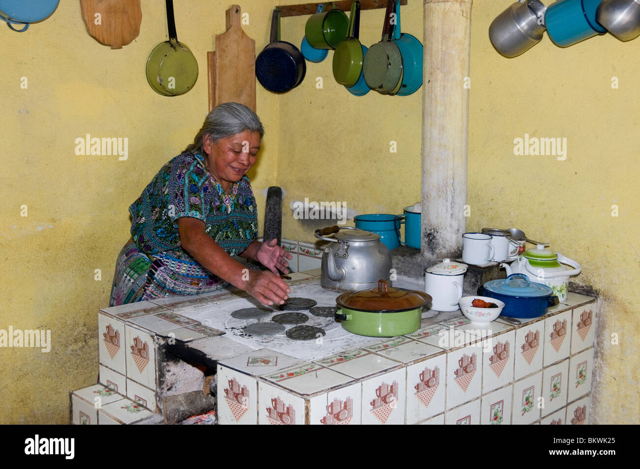 Mayan woman cooking tortillas on traditional oven Guatemala Stock Photo