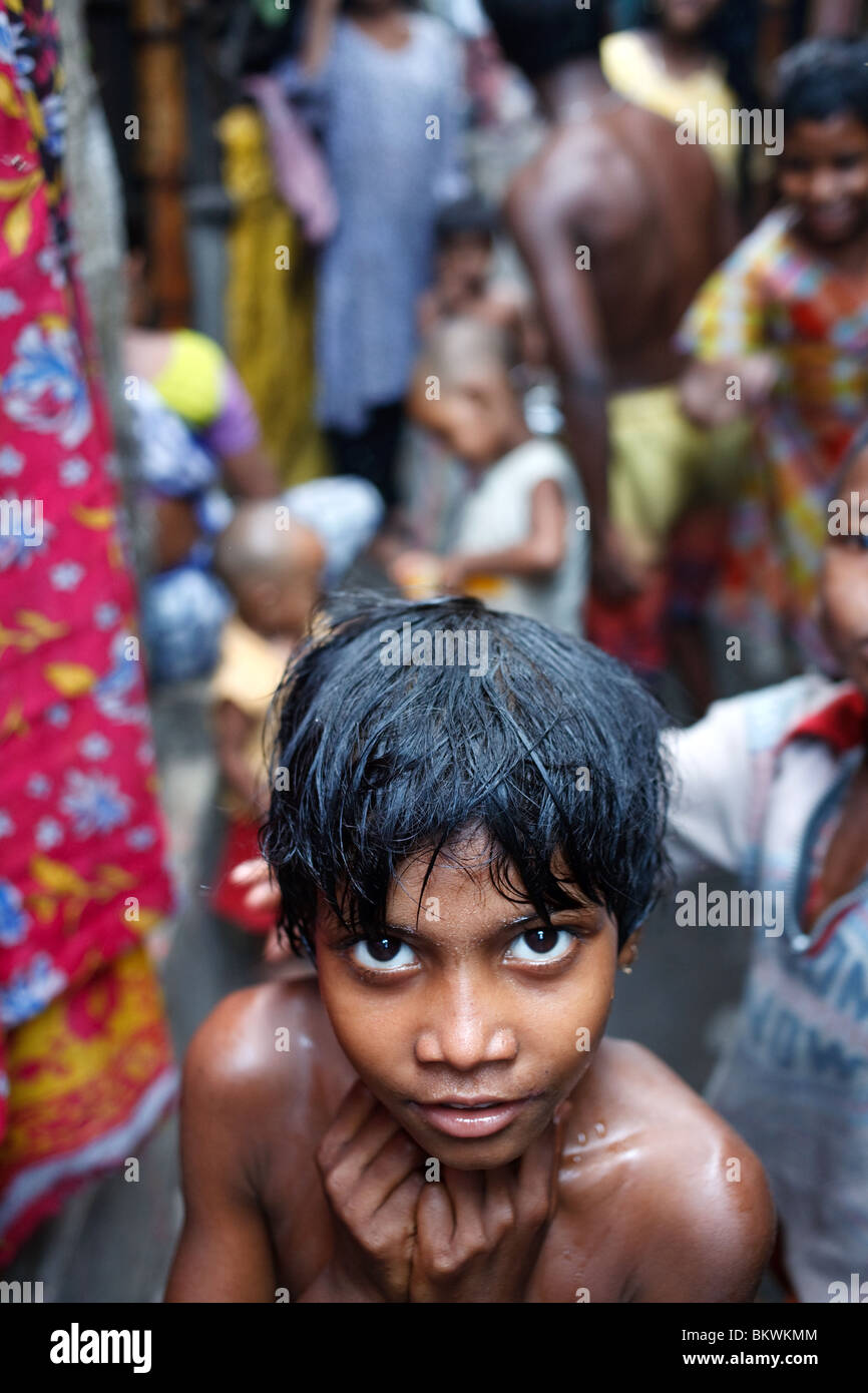 A portrait of a young boy in a crowded slum alley in Kolkata, India. Stock Photo