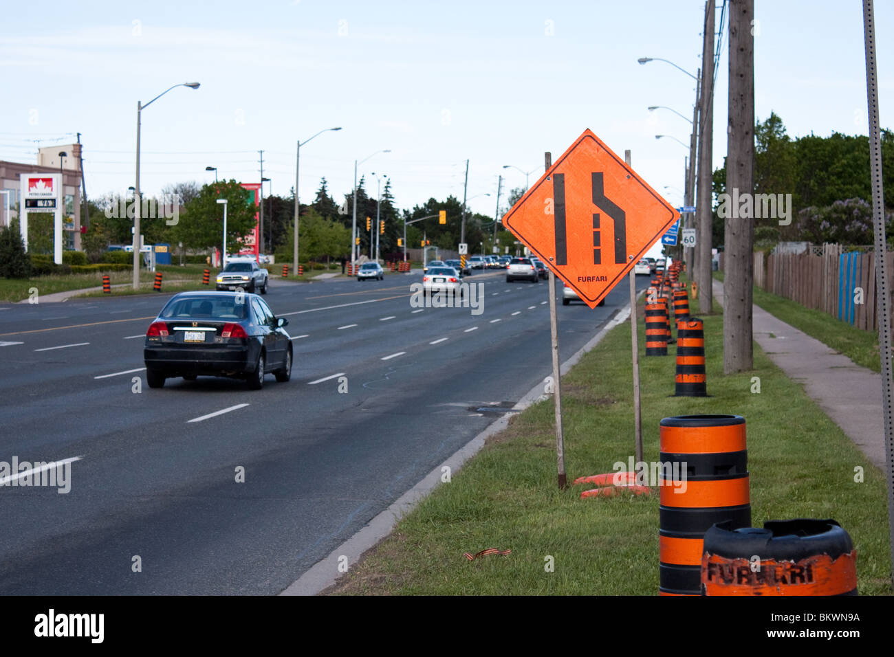 road traffic sign lane end orange car Stock Photo