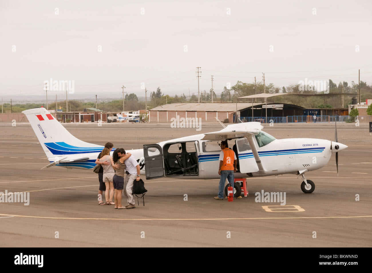 Passengers hugging in relief after safely landing from bumpy flight over Nazca lines, Peru Stock Photo