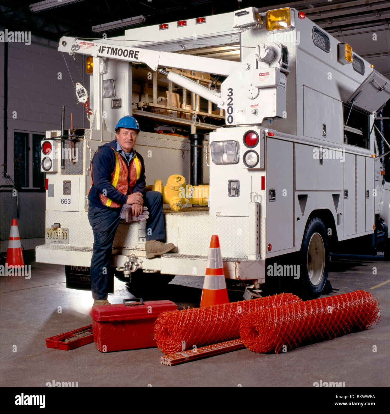 Employee of water company pose for a photograph with a utility truck