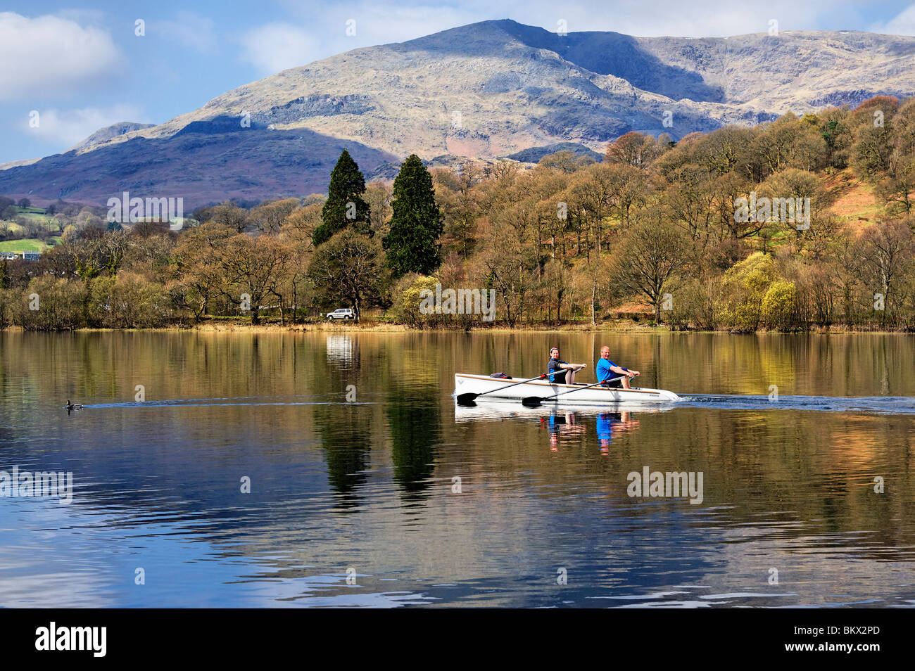 Couple, man and woman, rowing a boat on Coniston Water, in Lake District, Cumbria Stock Photo
