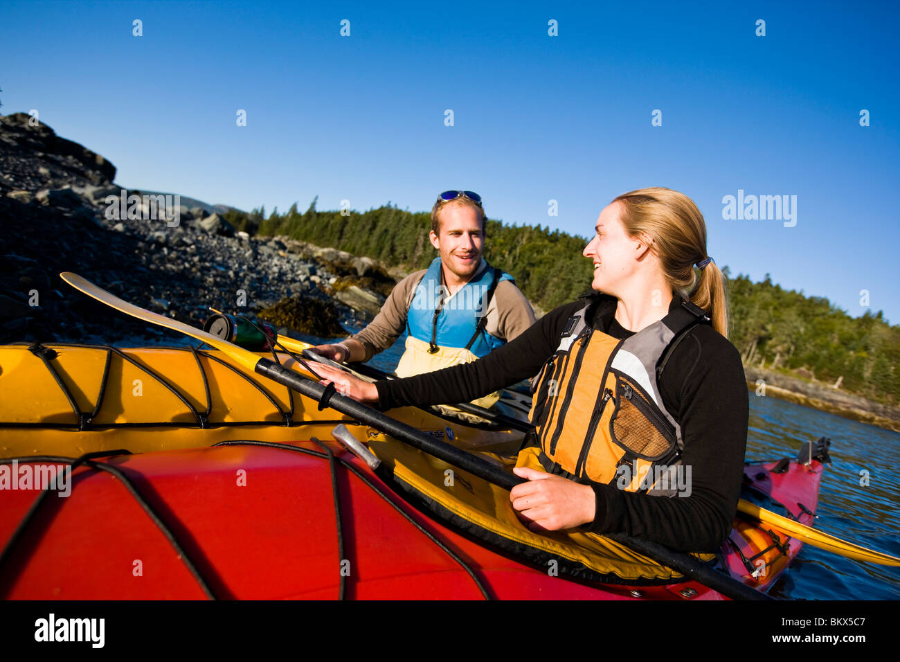 A young couple sea kayaking near the Porcupine Islands in Maine's