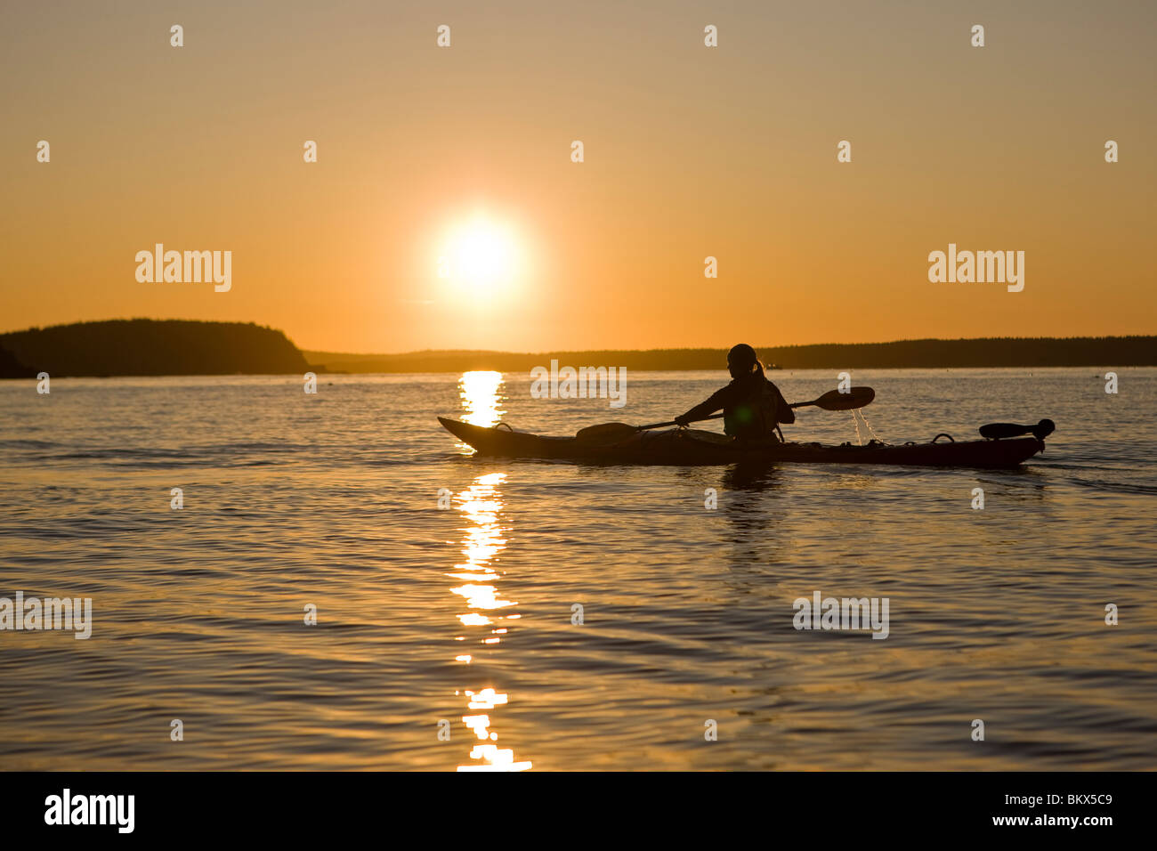 A woman sea kayaking near Sheep Porcupine Island in Maine's Acadia
