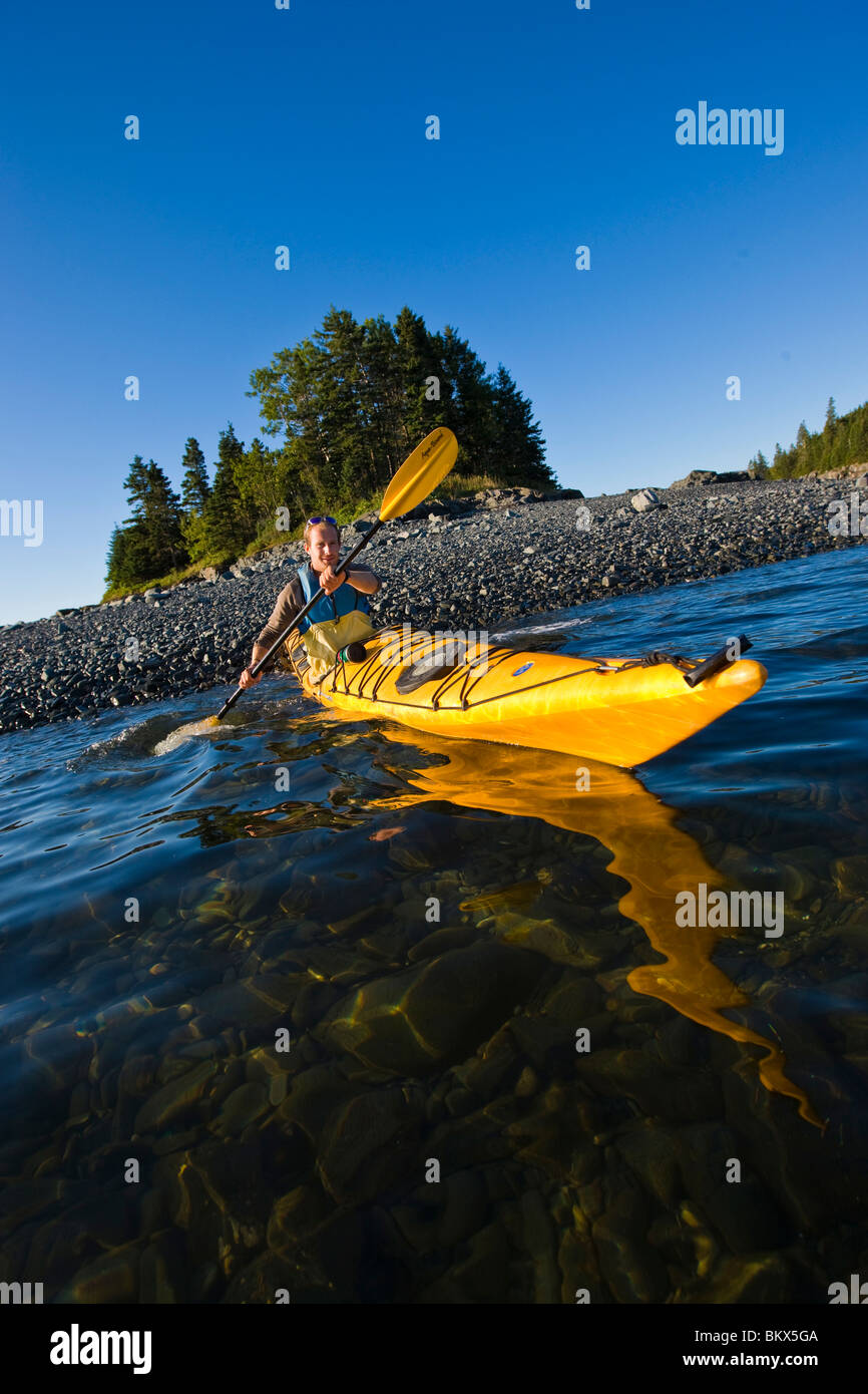 A man sea kayaking near the Porcupine Islands in Maine's Acadia