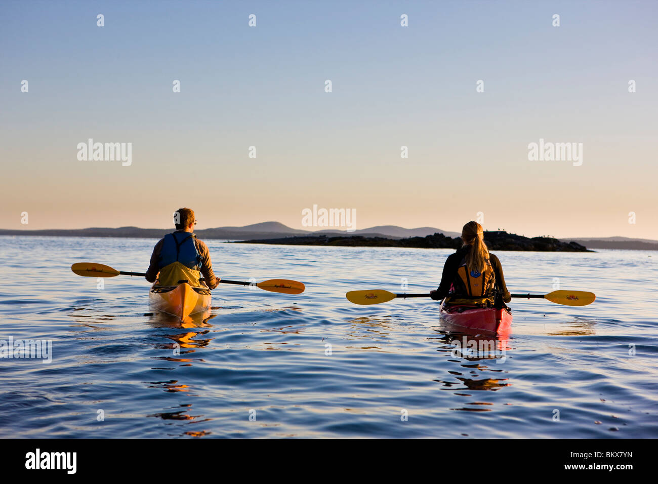 A man and woman sea kayaking near Sheep Porcupine Island in Maine's