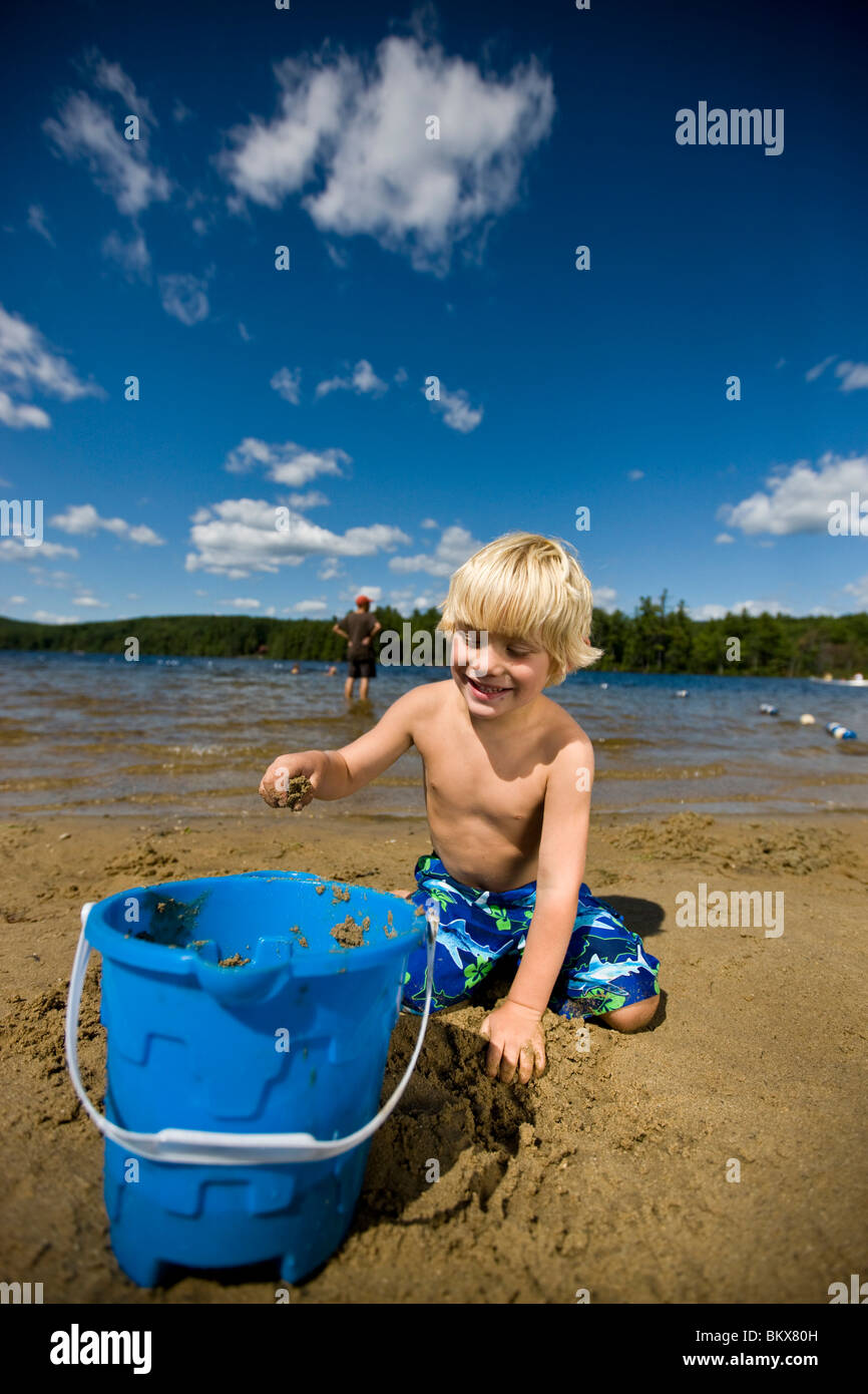 A boy plays on the beach at Otter Lake in Greenfield State Park in Greenfield, New Hampshire