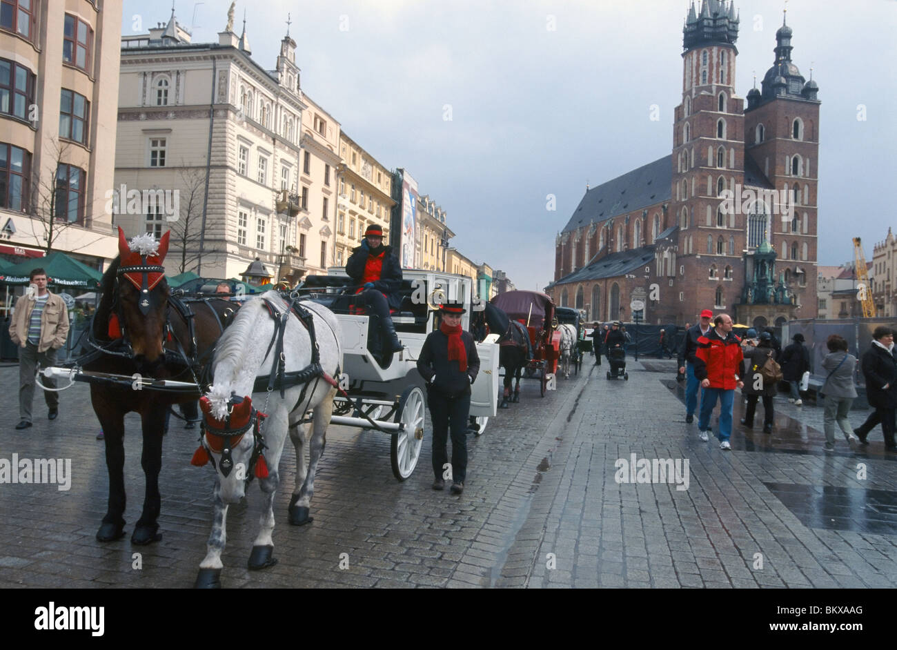 Krakow, April 2010 -- Horse-drawn carriage on main market square. St. Mary's Basilica is in the background. Stock Photo