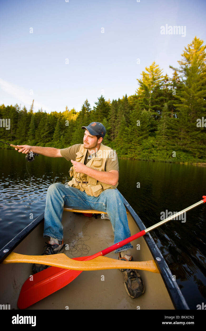 A man flyfishing from a canoe on Little Greenough Pond in Errol, New Hampshire Stock Photo Alamy