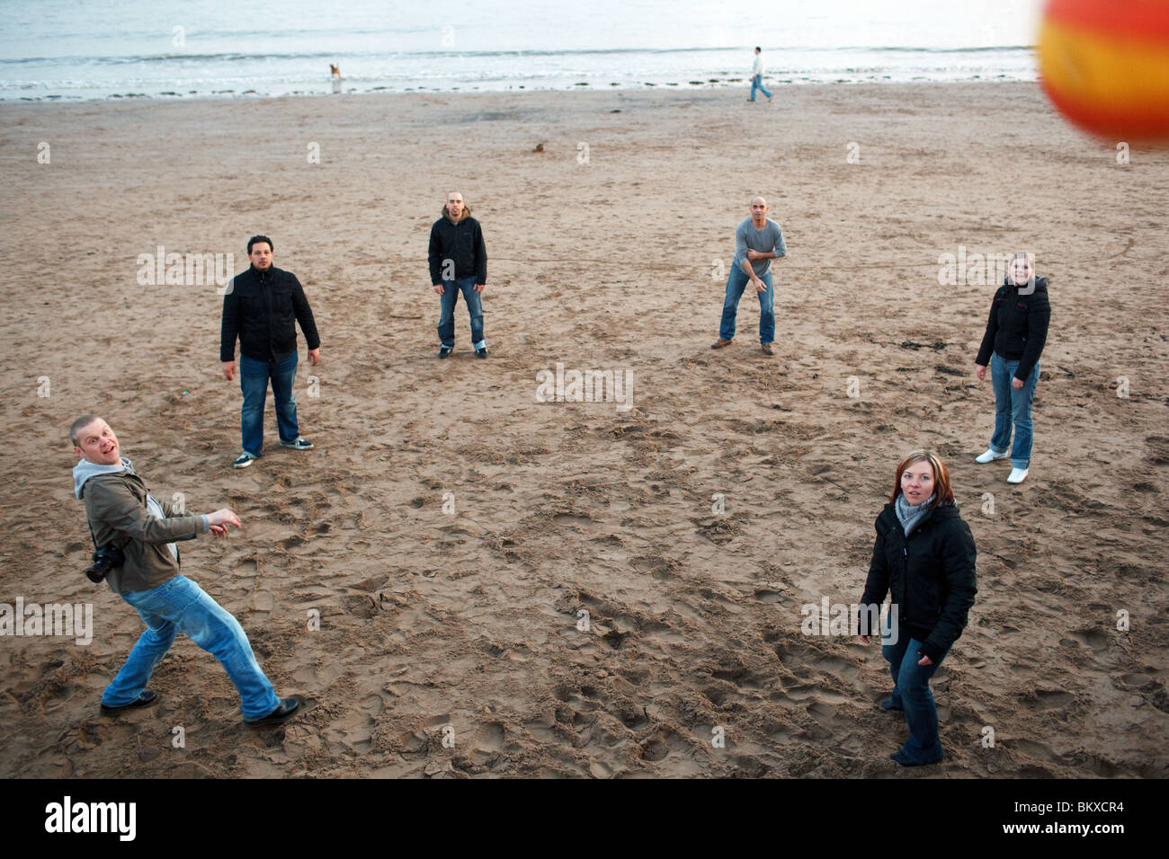 Young people play ball on the beach in Barry Island near Cardiff, UK. Stock Photo