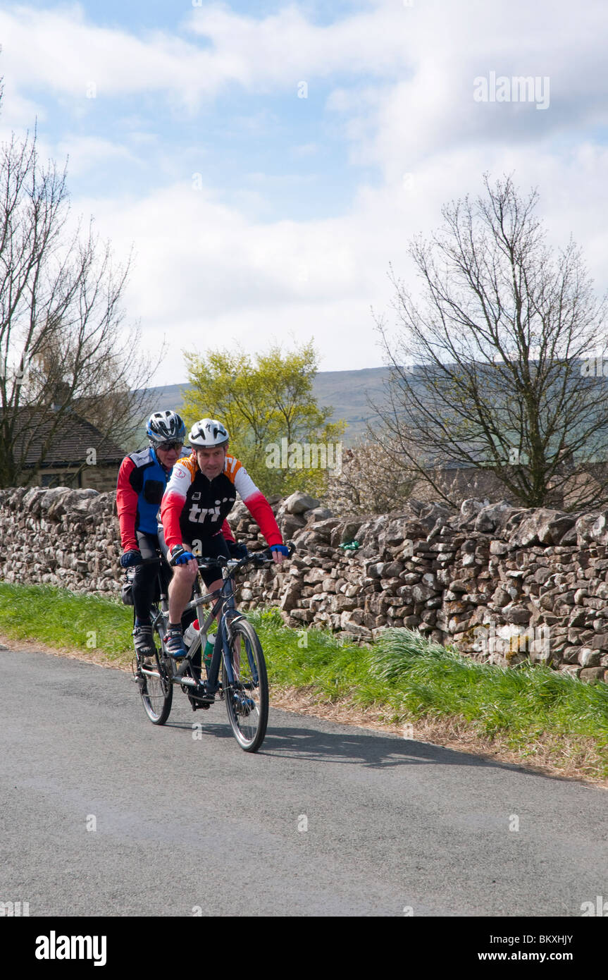 Cyclists riding a tandem near village of Grassington in the Yorkshire Dales and Linton Falls Stock Photo