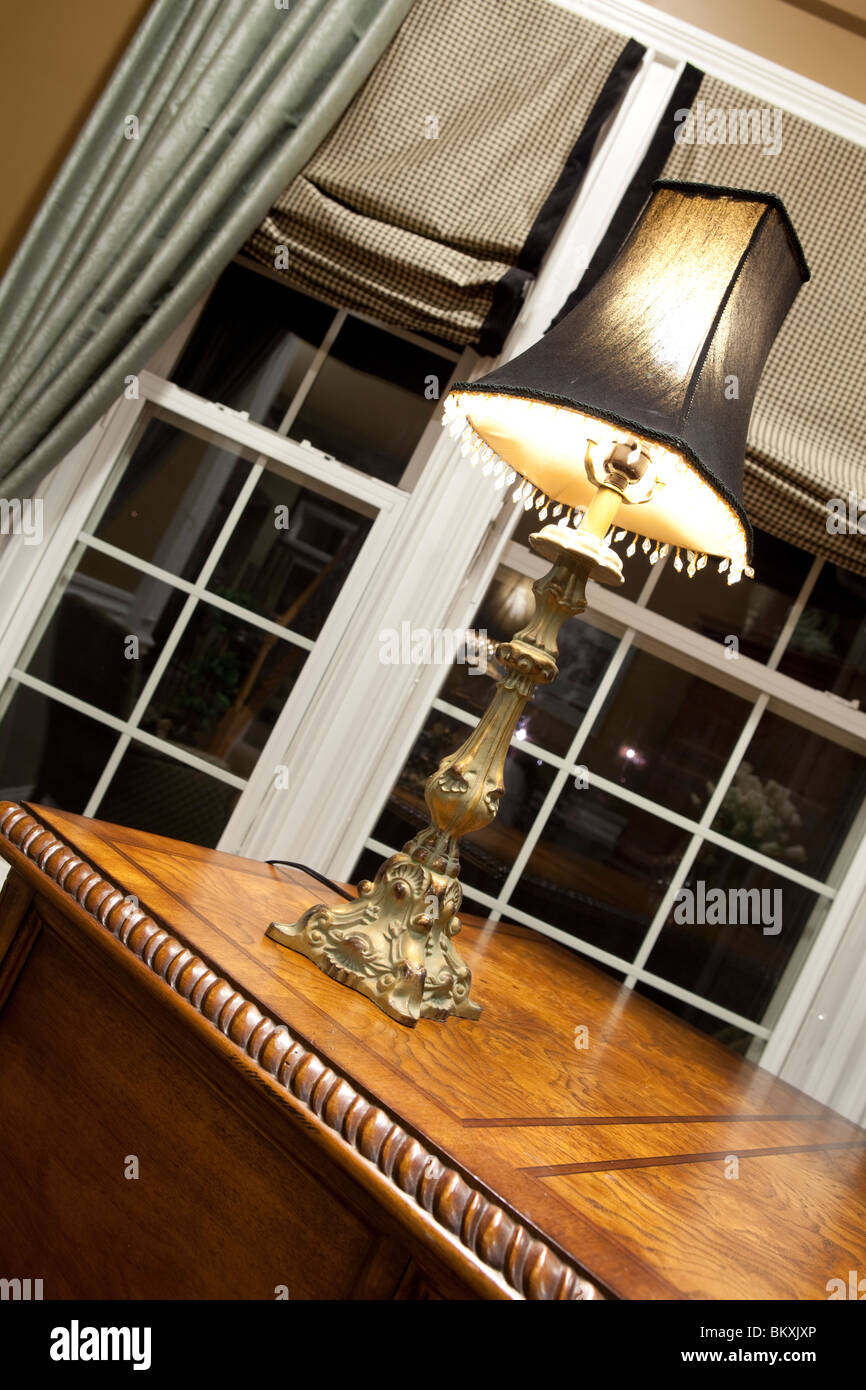 HOME OFFICE DETAIL. WOODEN TABLE, LAMP AND MATCHING COLOR CURTAINS Stock Photo