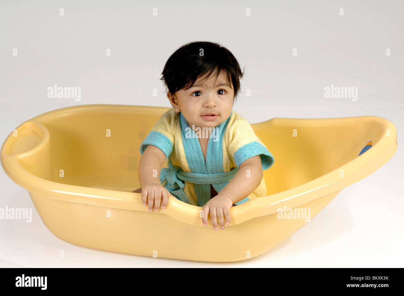 Indian Baby playing in yellow bath tub ; MR Stock Photo Alamy