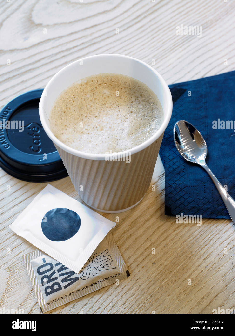 Italian cappuccino in a take away cup with sugar Stock Photo