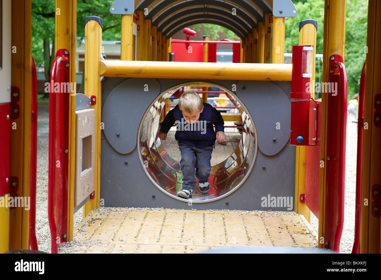child-blond-boy-sliding-down-the-slide-on-the-playground-stock-photo