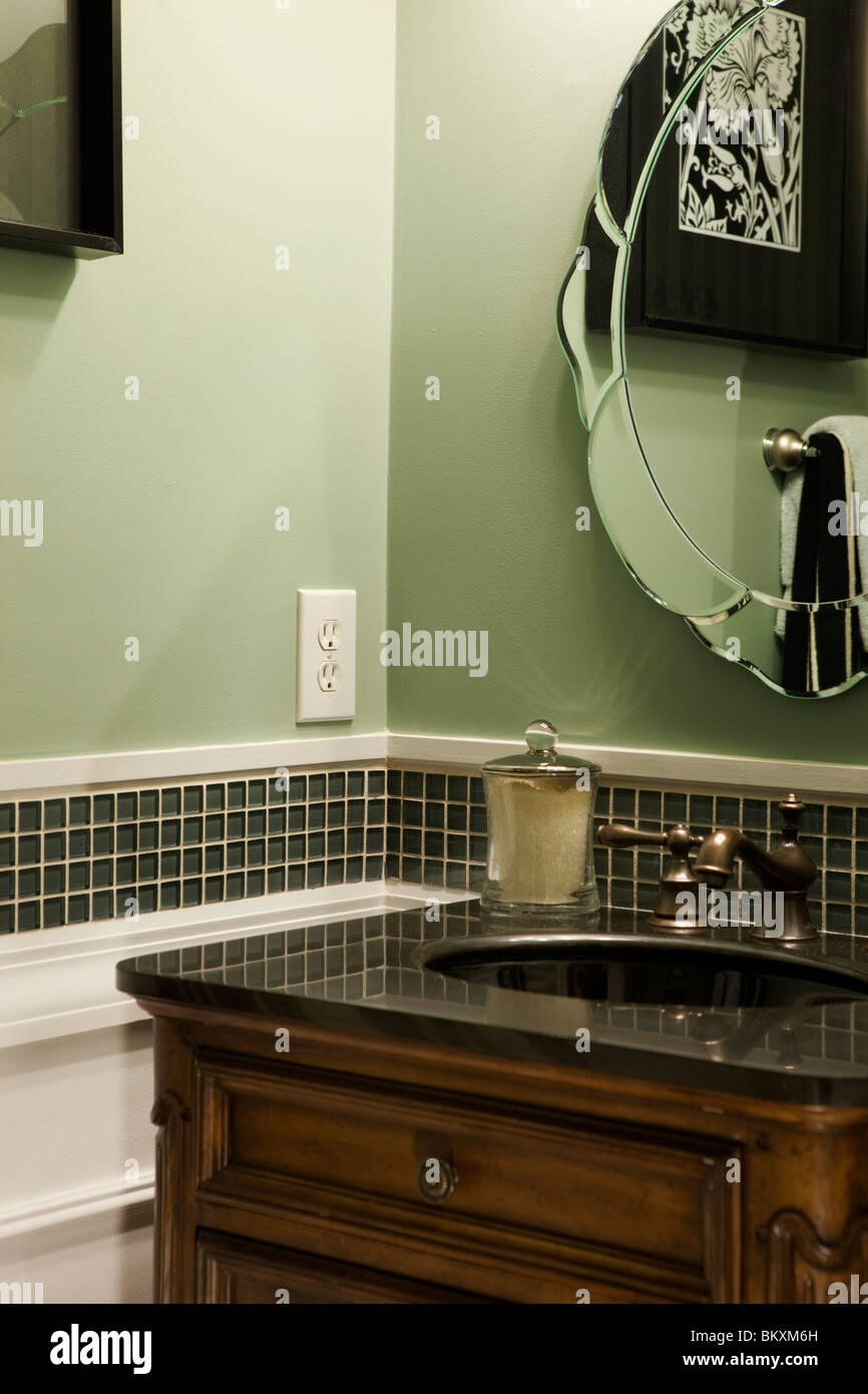 Small green guests bathroom . Mirror reflecting furnishings Stock Photo