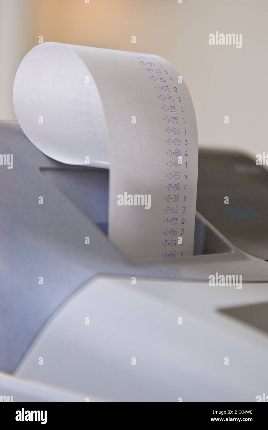 Close up of a cash register with receipt coming out of it Stock Photo