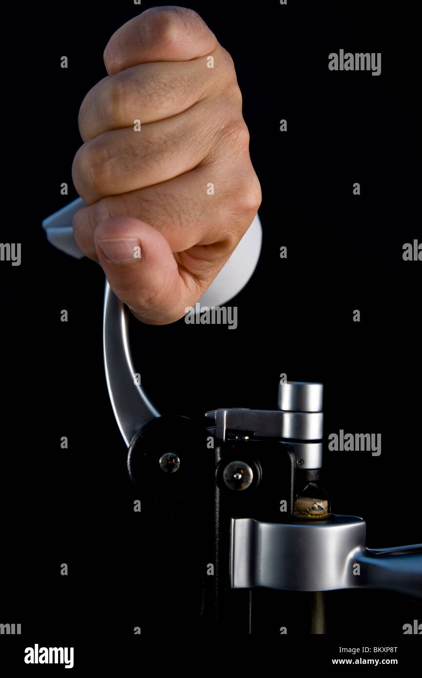Close up of a waiter hands opening a bottle of wine with a screwpull lever corkscrew Stock Photo