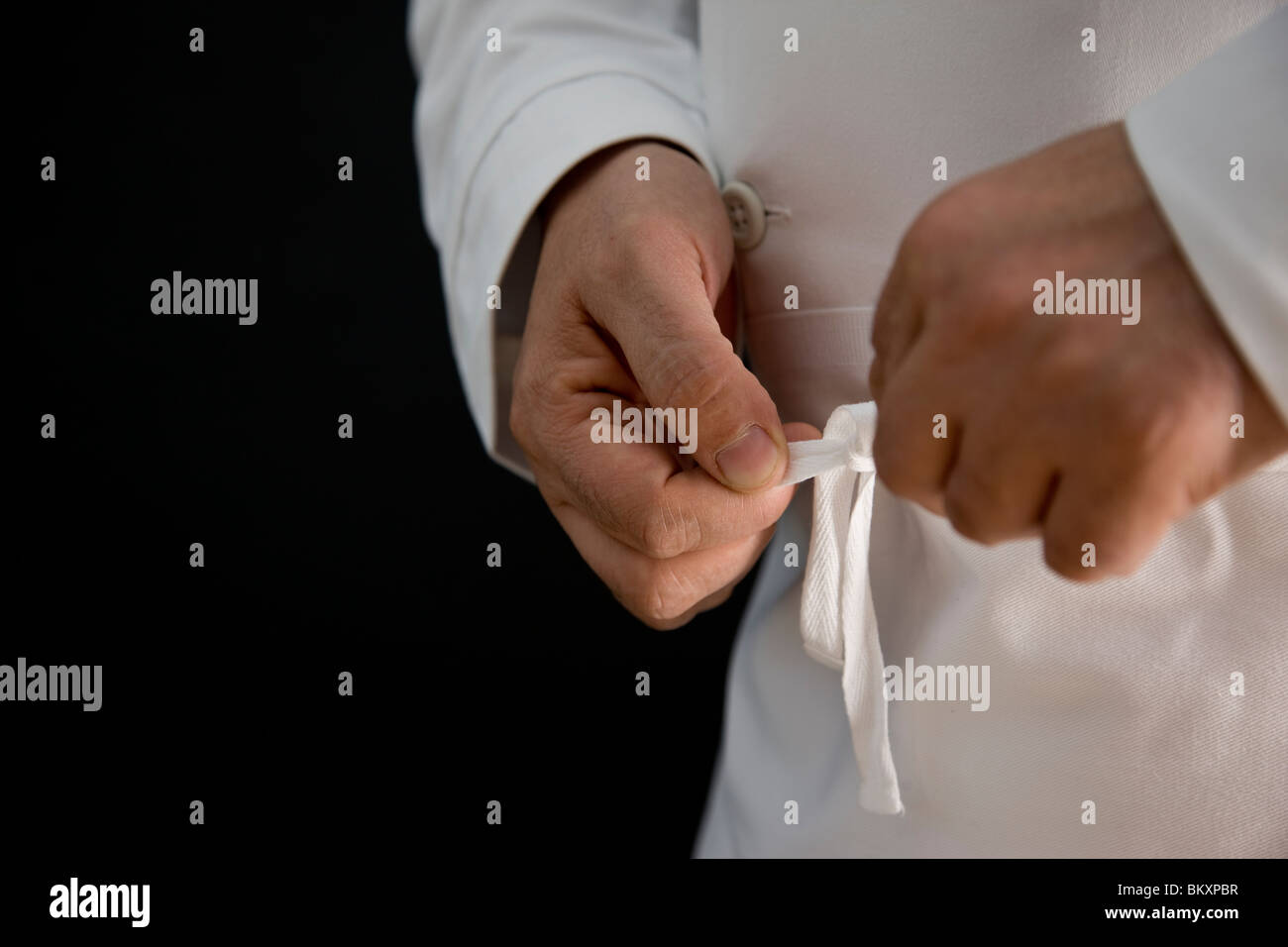 Close up of a chef hands fastening his apron Stock Photo