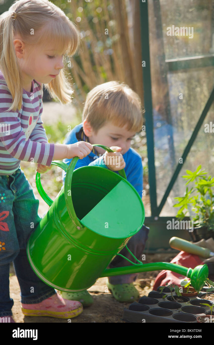 Girl And Boy Watering Plants High Resolution Stock Photography and ...