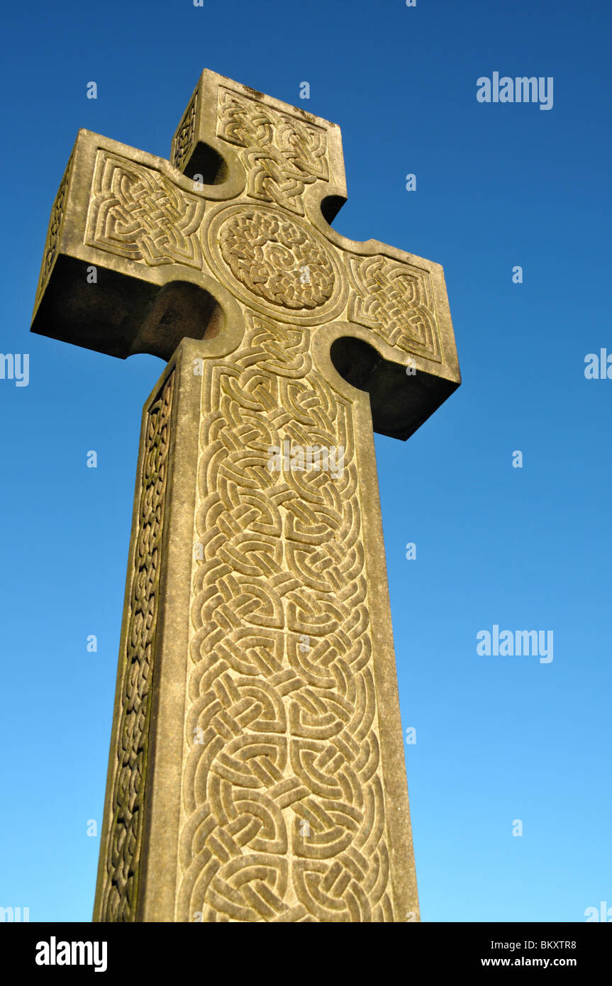 a Celtic cross gravestone engraved with Celtic knot design. Stock Photo