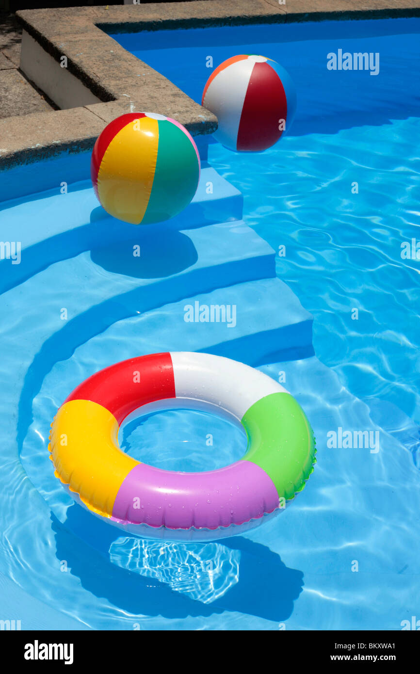 Inflatable rubber ring and beach balls floating in a blue swimming pool  Stock Photo - Alamy