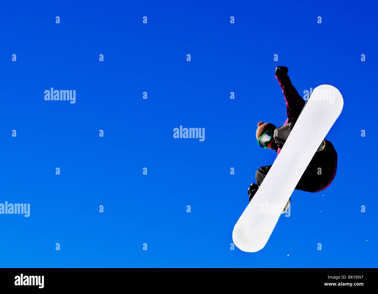 Man in midair jumping while snowboarding Stock Photo