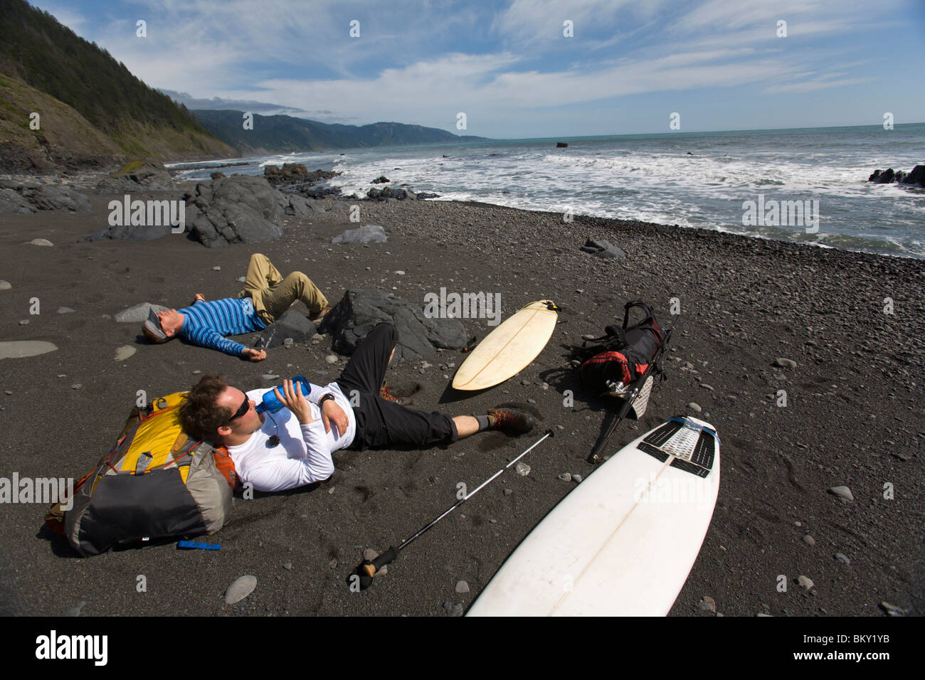 Two men backpack and surf on The Lost Coast, California Stock Photo Alamy