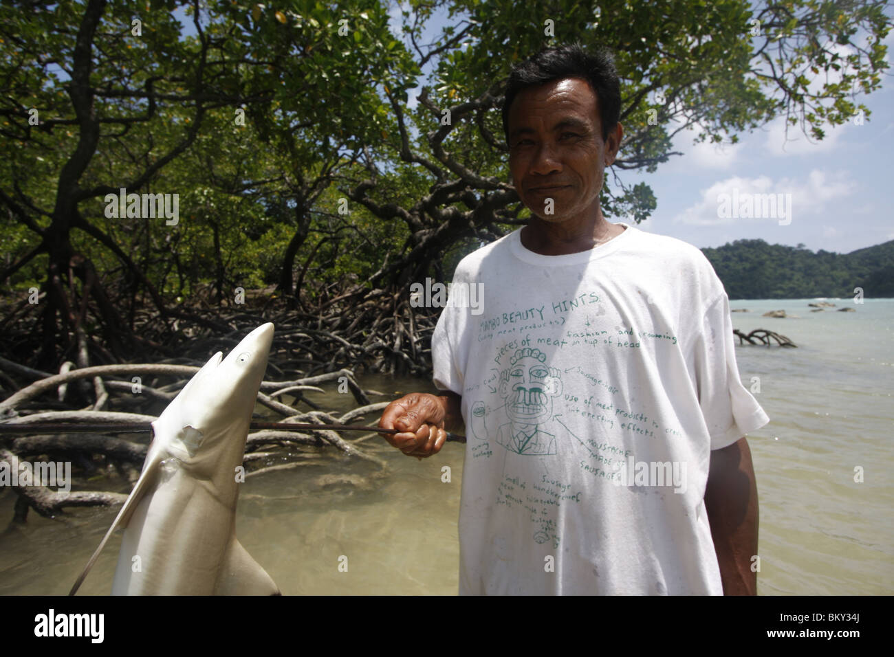 A Moken sea nomad has speared a young black-tip reef shark in Ko Surin, marine national park, Thailand Stock Photo