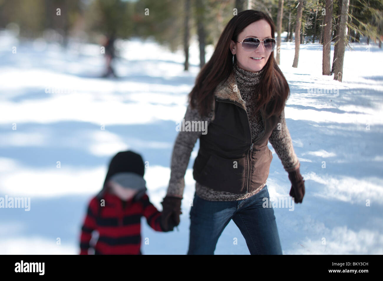 A mother snowshoes with her 4 yearold son in the snow covered