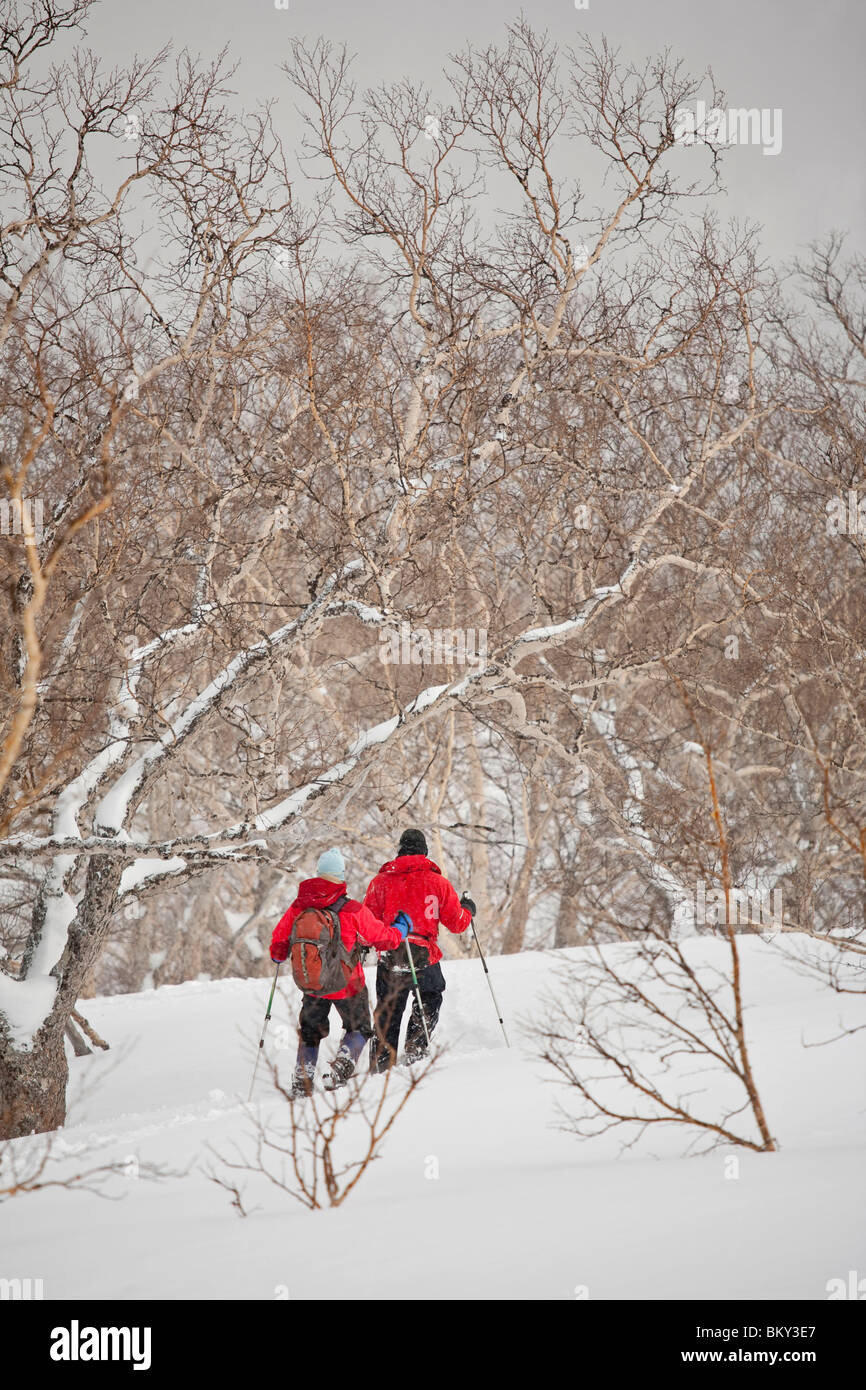 Two people are snowshoeing down a slope in Daisetsuzan National Park
