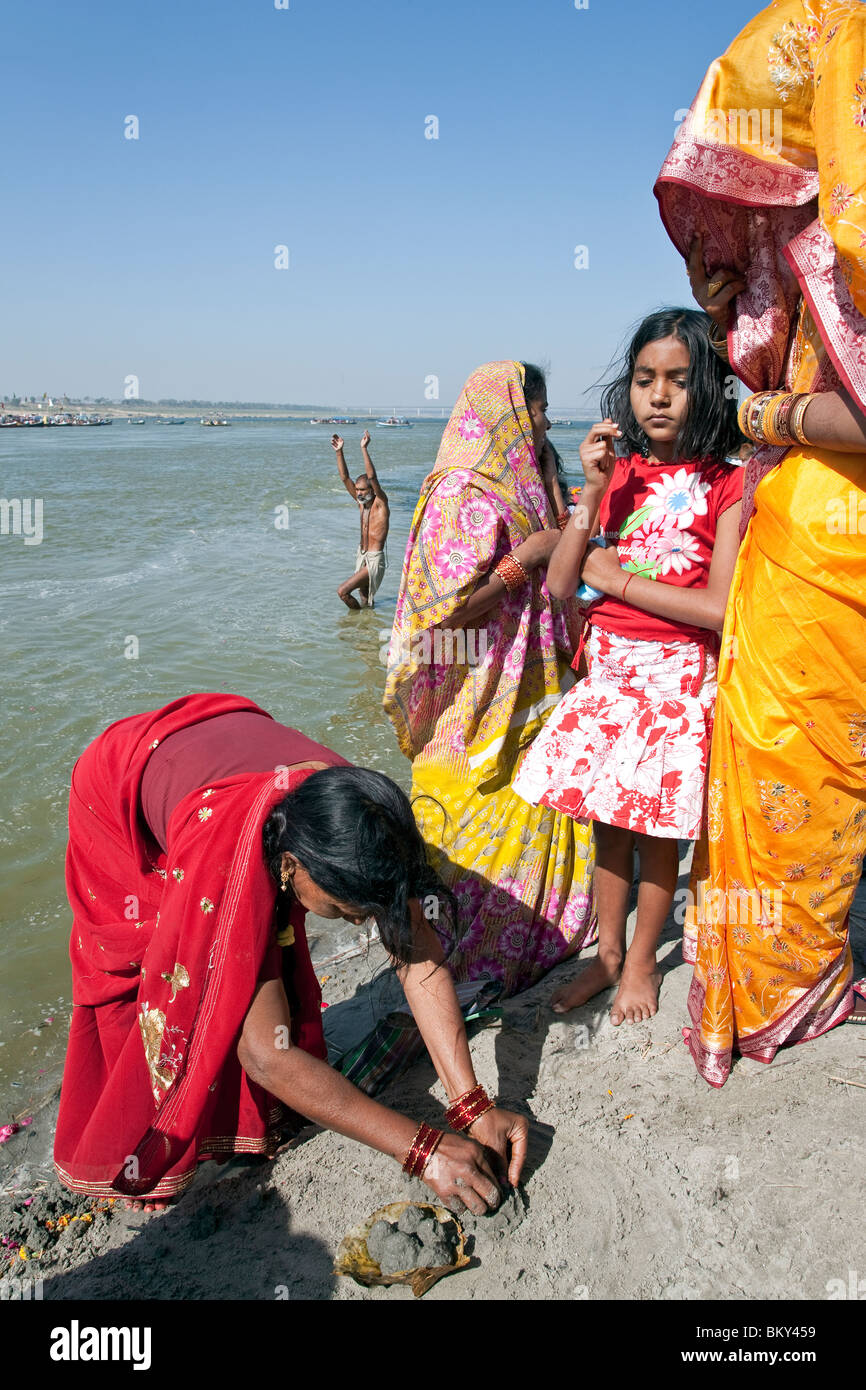 Indian women making a traditional river offering (puja). Ganges river. Allahabad. India Stock Photo