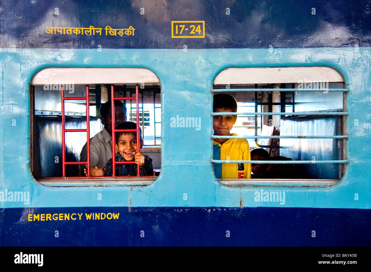 Children looking through a train window, Varanasi, Uttar Pradesh, India Stock Photo