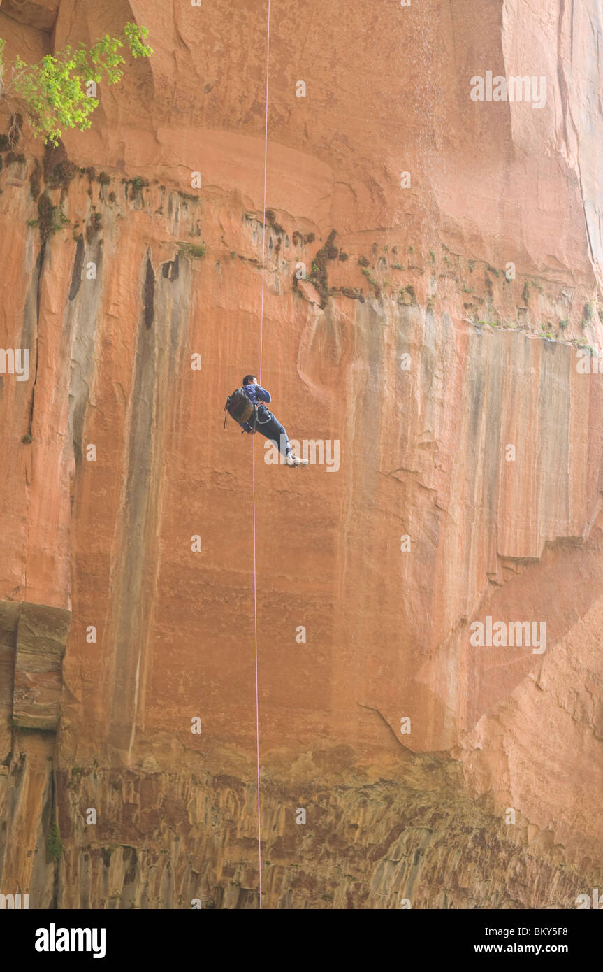 A canyoneering man completing a free rappel at the end of Heaps Canyon