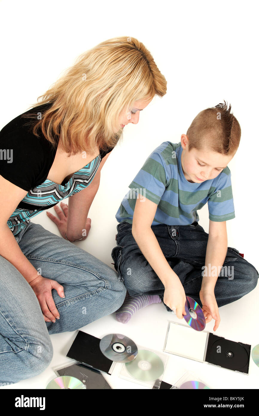 Portrait of young mother with son putting CDs in holders, studio shot Stock Photo