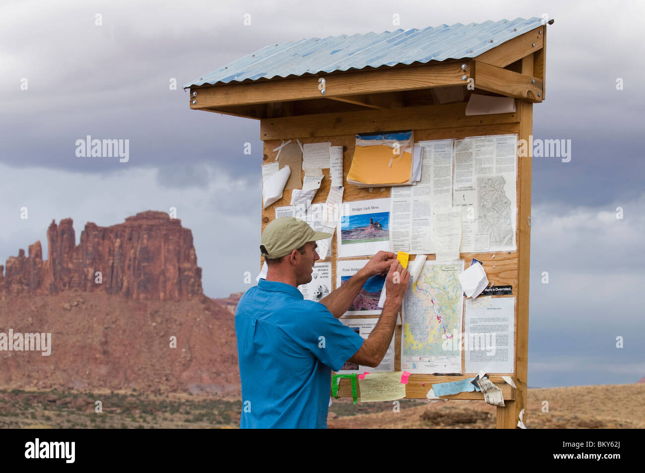 A hiker posting a message on a board at a trailhead, Indian Creek, Monticello, Utah. Stock Photo