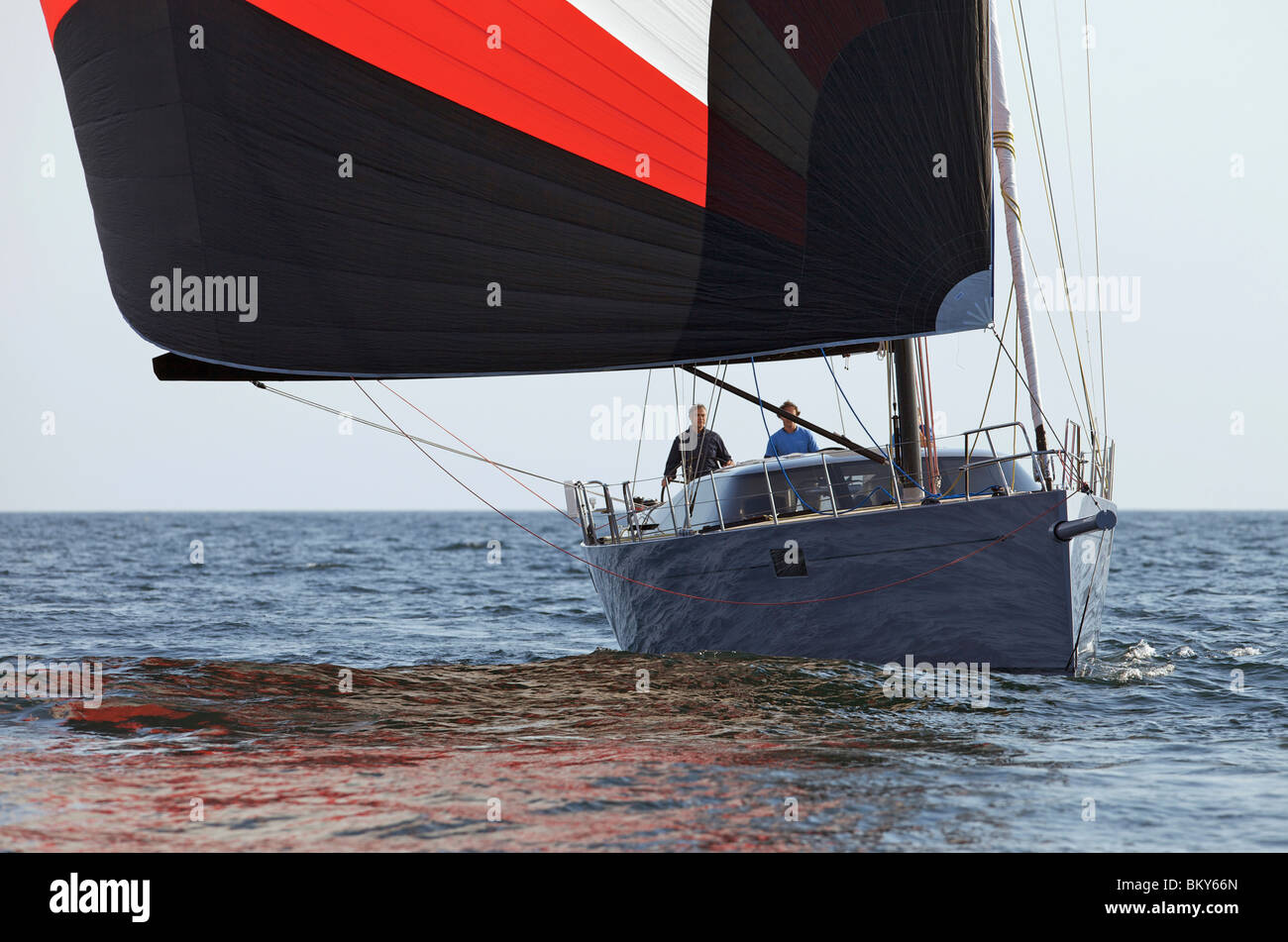 A crew races a modern ocean-going sailing yacht under spinnaker. Stock Photo