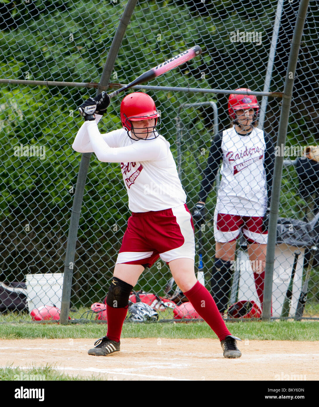 A high school girls softball game. A batter at bat at home plate Stock