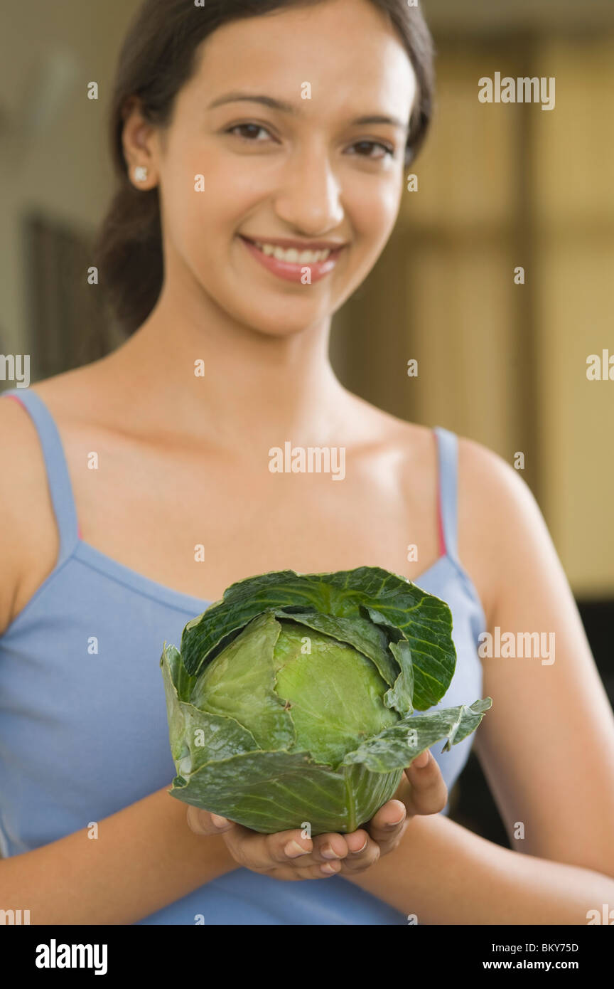 Woman holding a cabbage and smiling Stock Photo