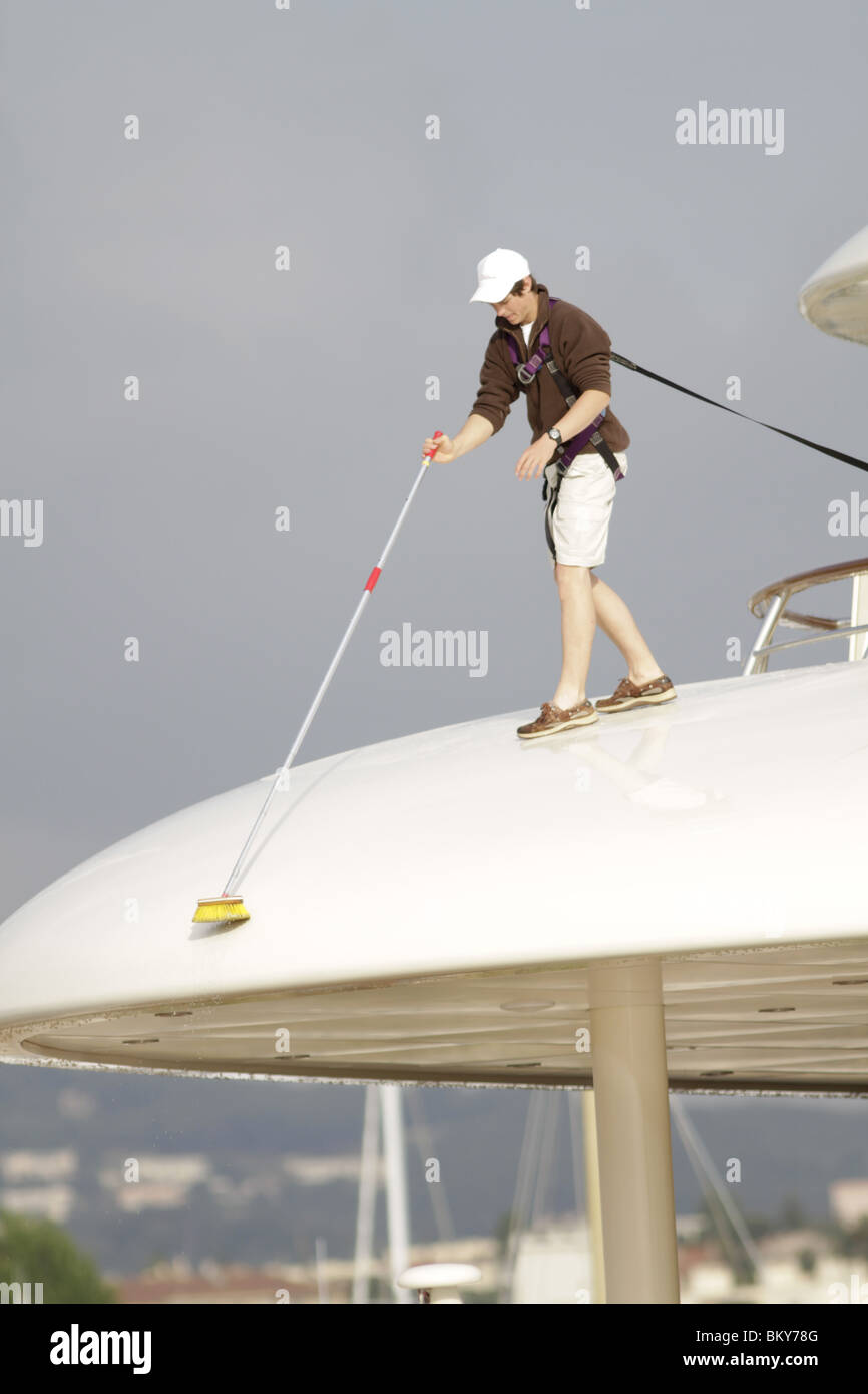Deckhands wash a luxury super yacht moored in Port Vauban, Antibes