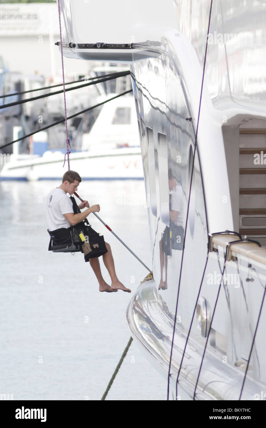 Deckhands wash a luxury super yacht moored in Port Vauban, Antibes
