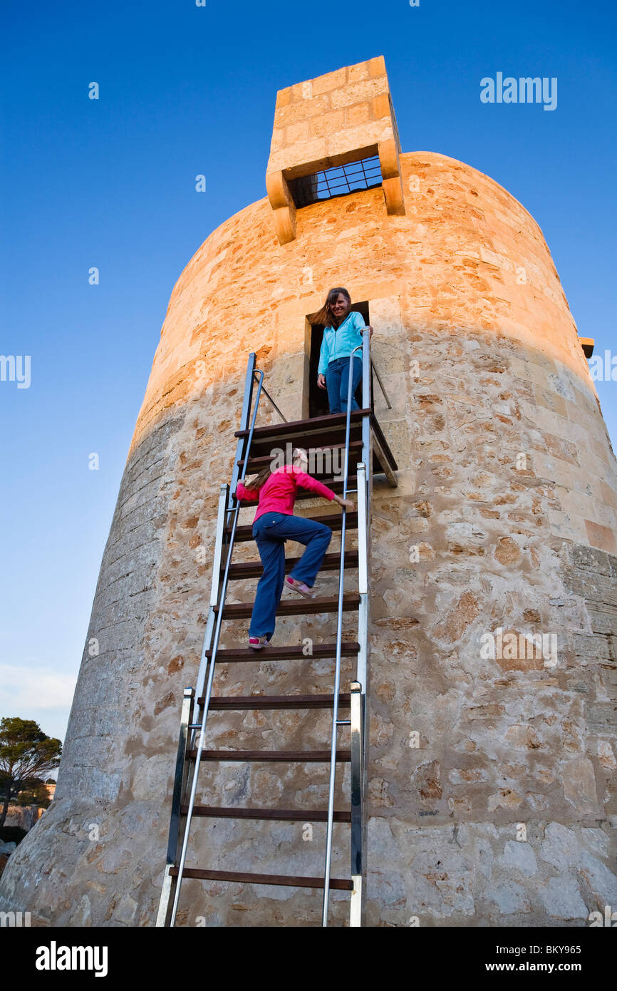 Two girls on the ancient watchtower in the evening light, Cala Santanyi, Mallorca, Balearic Islands, Mediterranean Sea, Spain, E Stock Photo
